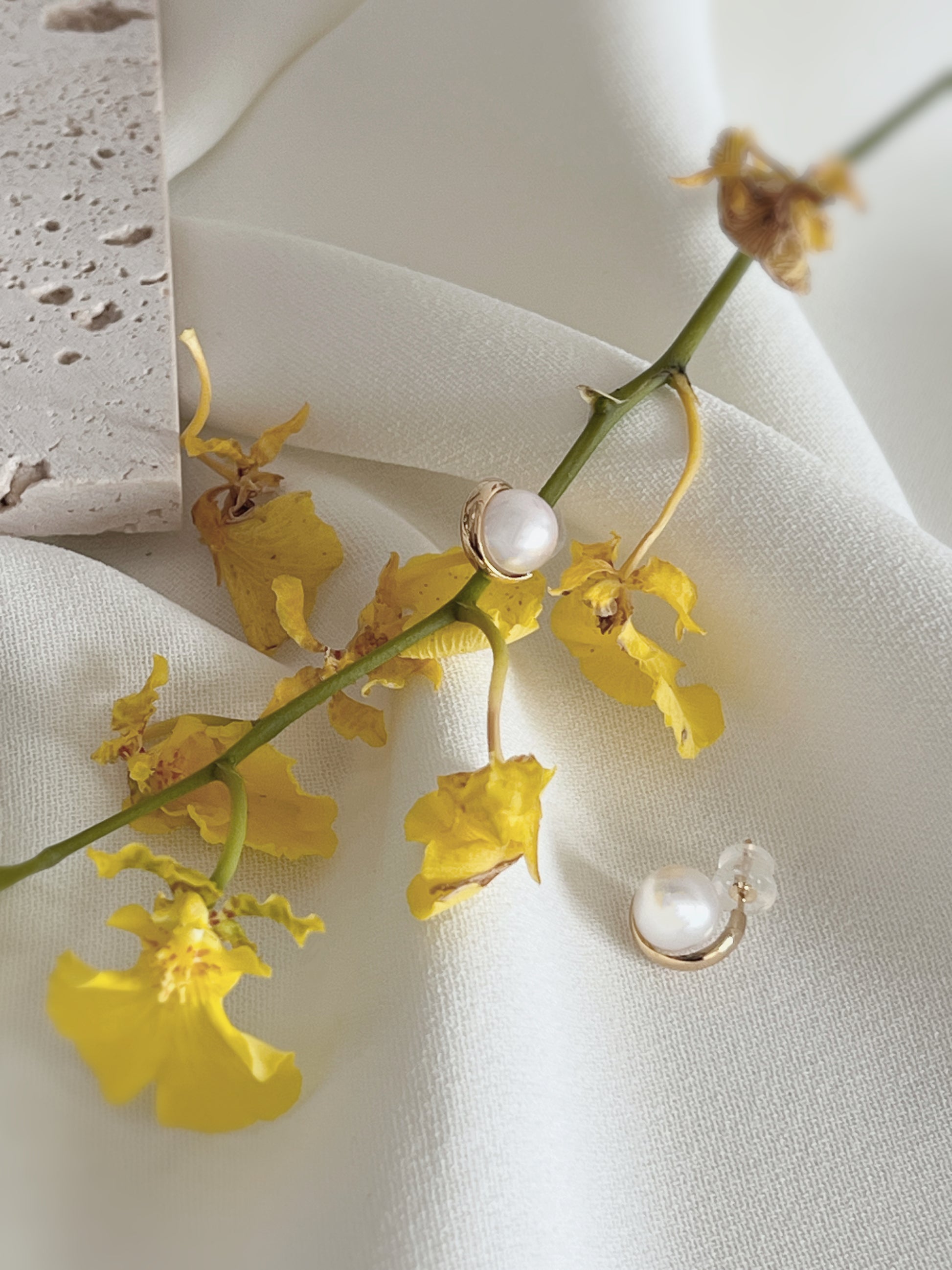 7.5mm Akoya Pearl earring with gold decoration surrounding it